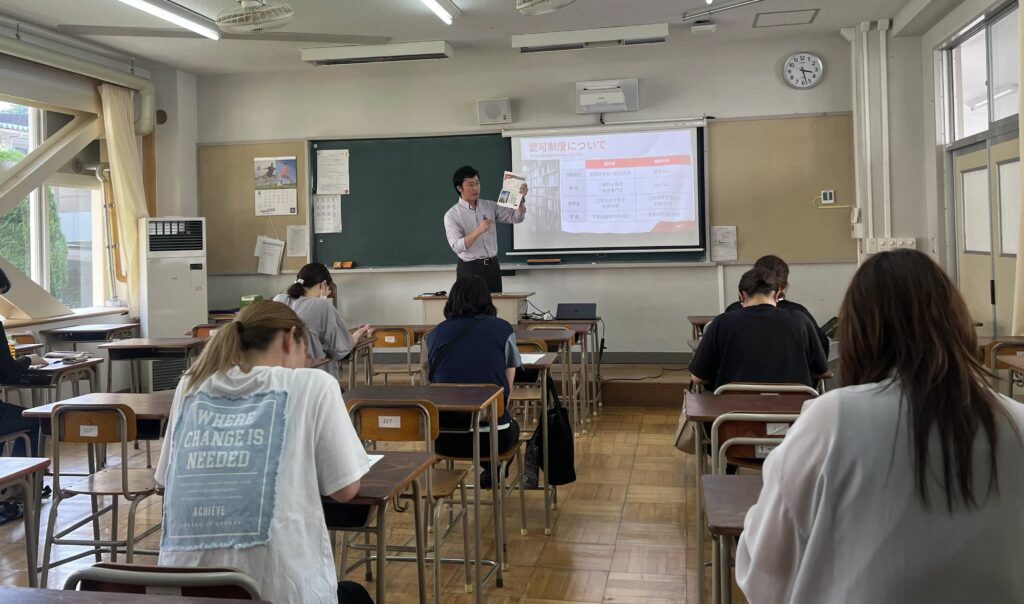 群馬県立渋川青翠高等学校の保護者が専門学校講演の資料を確認しながらメモを取っている様子